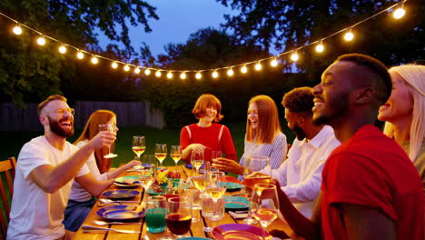 friends enjoying an outdoor dinner party and toasting