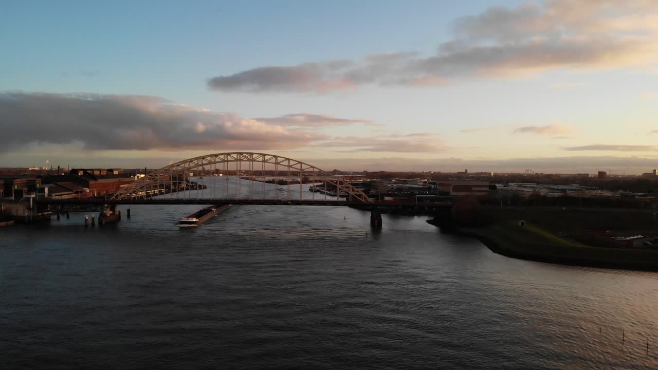 일몰 동안 다리를 지나가는 평화로운 바다를 여행하는 배 - 공중 촬영