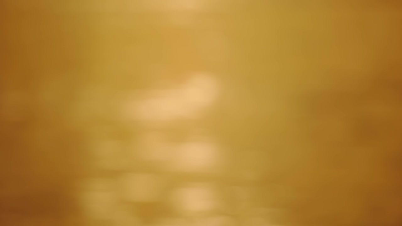 bokeh resplandor del sol reflejo de la luz del atardecer y el amanecer en la superficie del agua. rayos de sol parpadeando en el océano. ondas marinas doradas y brillantes en el sol abstracto borroso fuera de foco bokeh increíble fondo de otoño