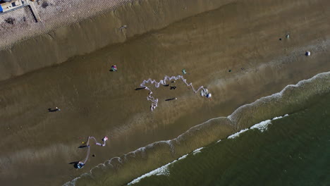 Aerial-birds-eye-descending-over-fishermen-cleaning-fishing-net-in-early-morning