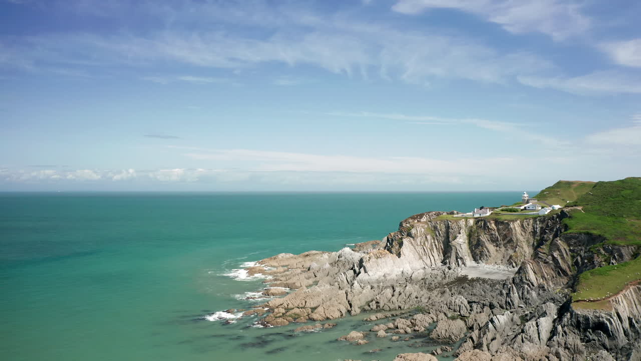 바위가 많은 해안선 위에 자리 잡은 등대의 공중 샷