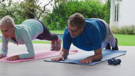 senior couple exercising in a garden