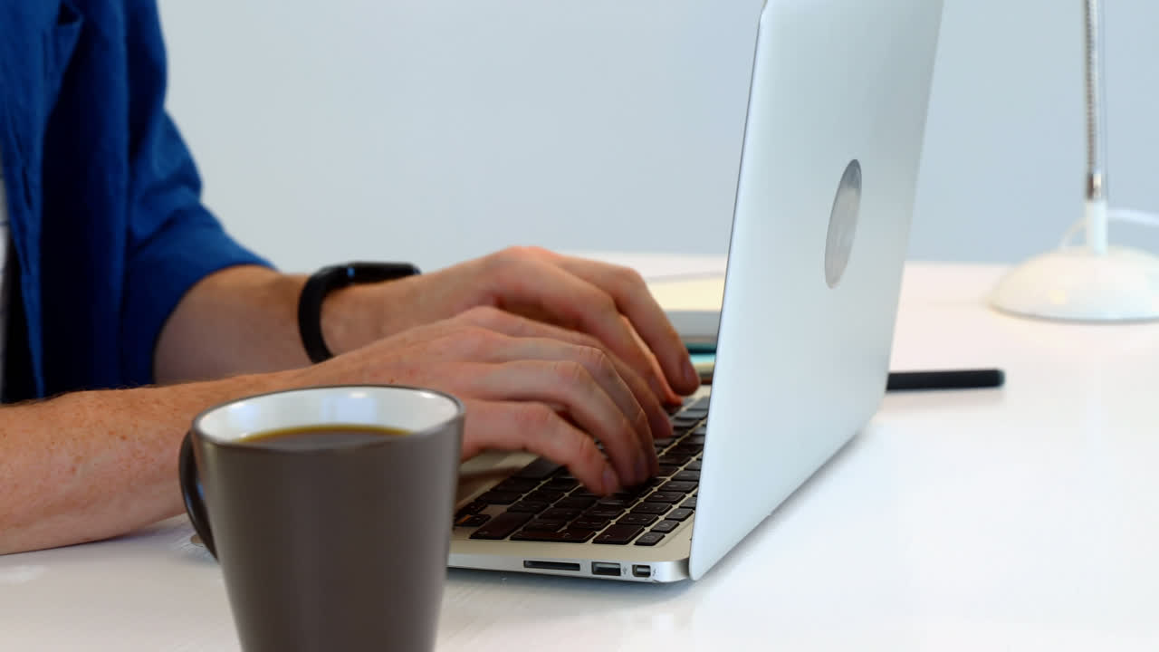 Man having coffee while using laptop on desk against white background 4k