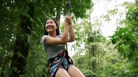 in central america, a young woman enjoys an exhilarating zipline experience high above the rainforest canopy as the sun sets. the vibrant greenery surrounds her, enhancing the excitement.