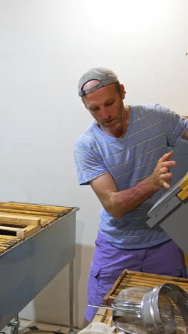 beekeeper inspecting honeycomb frames