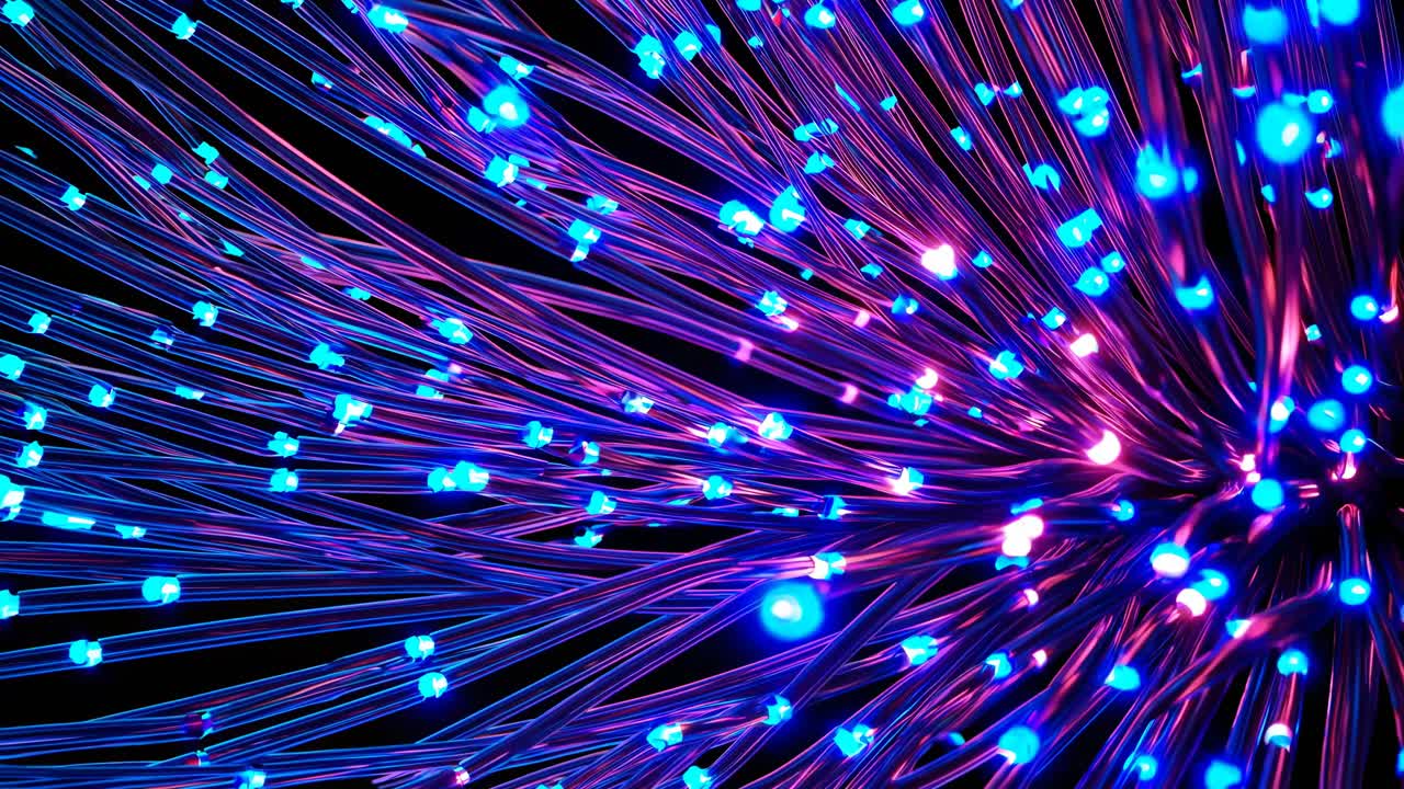 Primer plano dinámico de fibra óptica brillante en tonos vibrantes de azul y rosa, creando una atmósfera futurista.