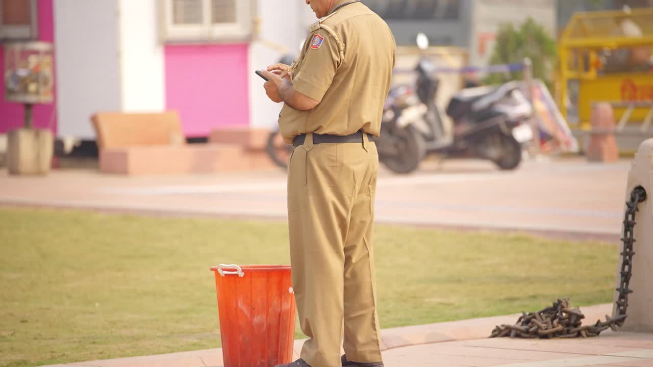 un policía indio usando un teléfono móvil