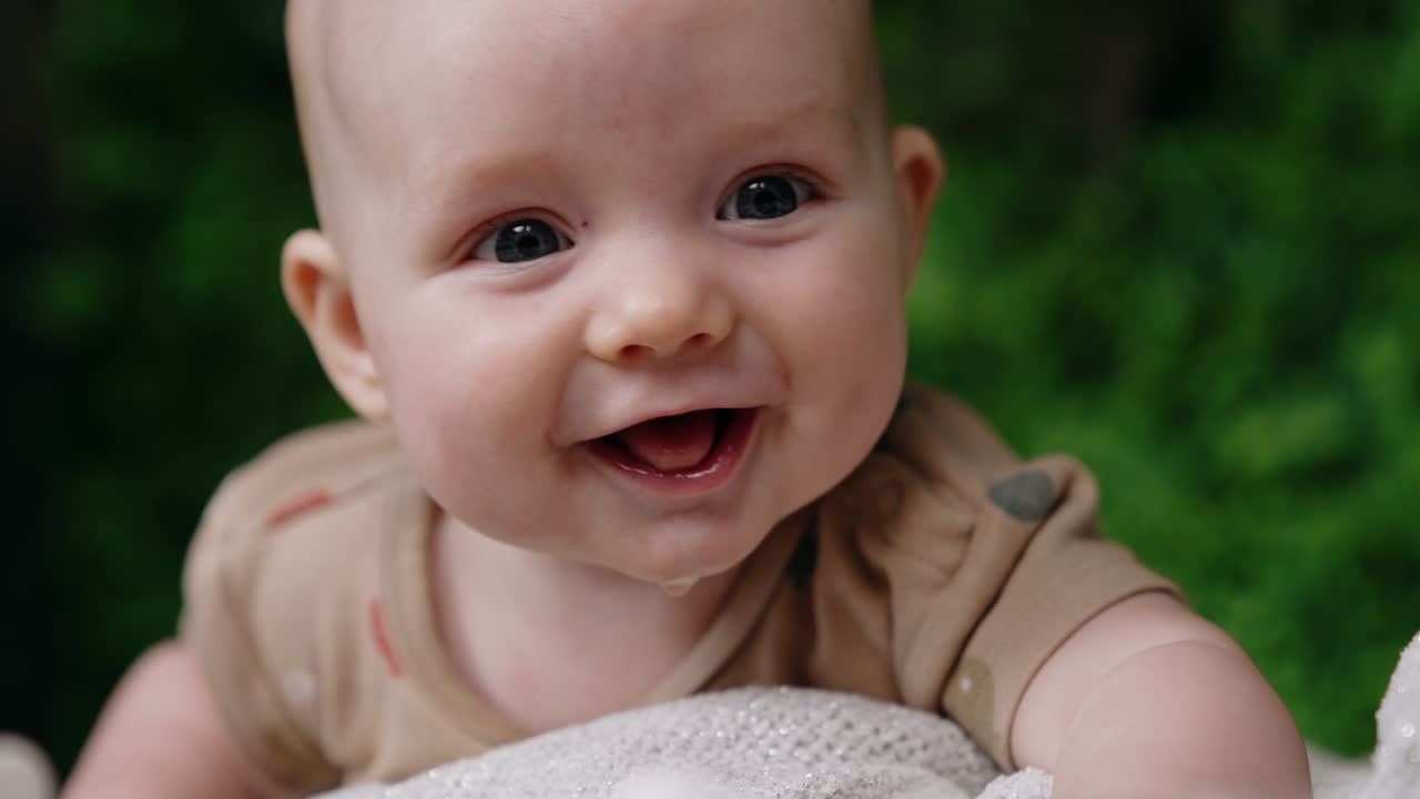 Adorable face of a cute infant baby. Lovely child smiling sweetly to camera. Close up.