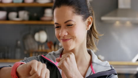 woman checking fitness tracker in kitchen