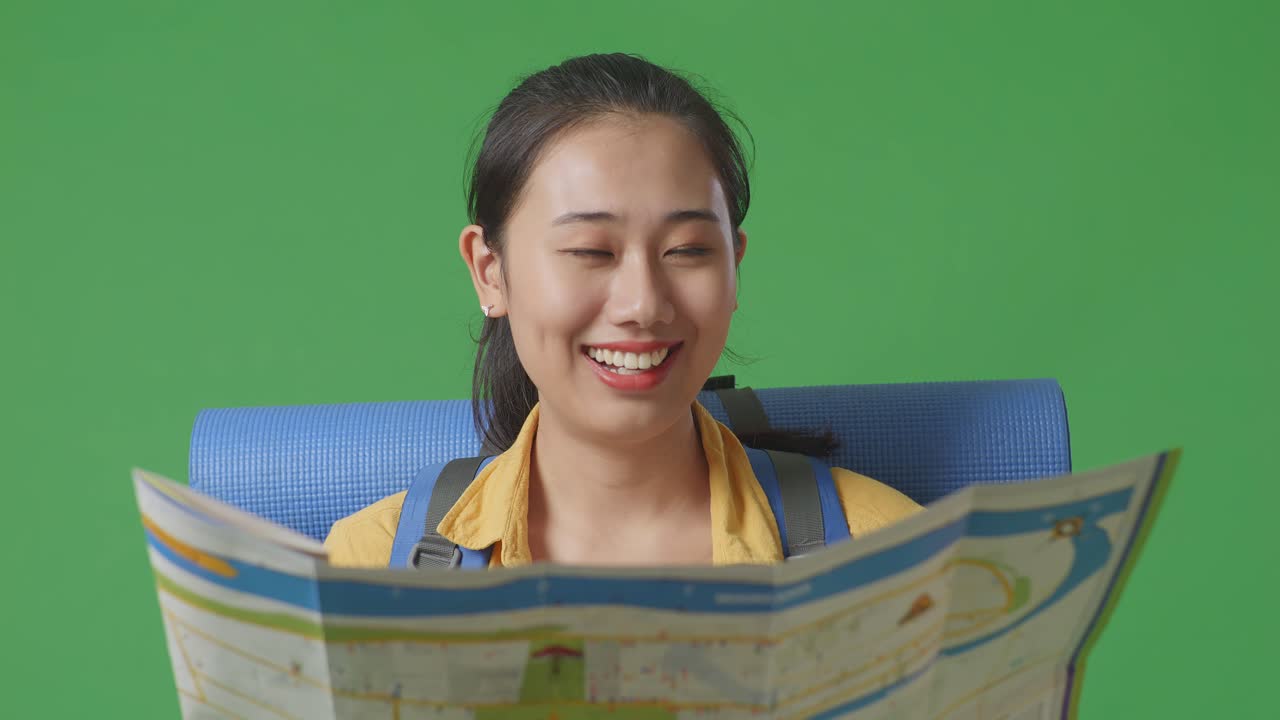 행복 한 관광 여성 이 지도 를 보고 있다