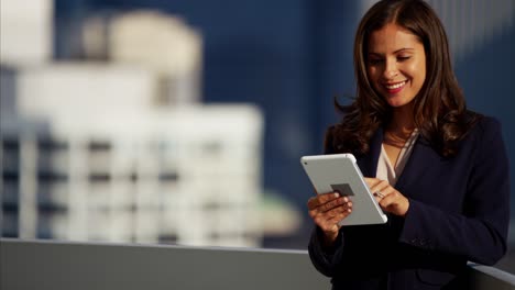 hispanic businesswoman using tablet technology on city rooftop