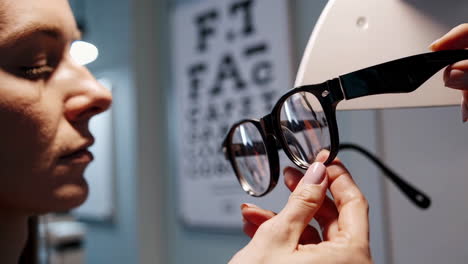 woman trying on glasses at optician