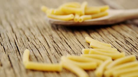 primer plano de pasta en una mesa de madera y una cuchara de madera