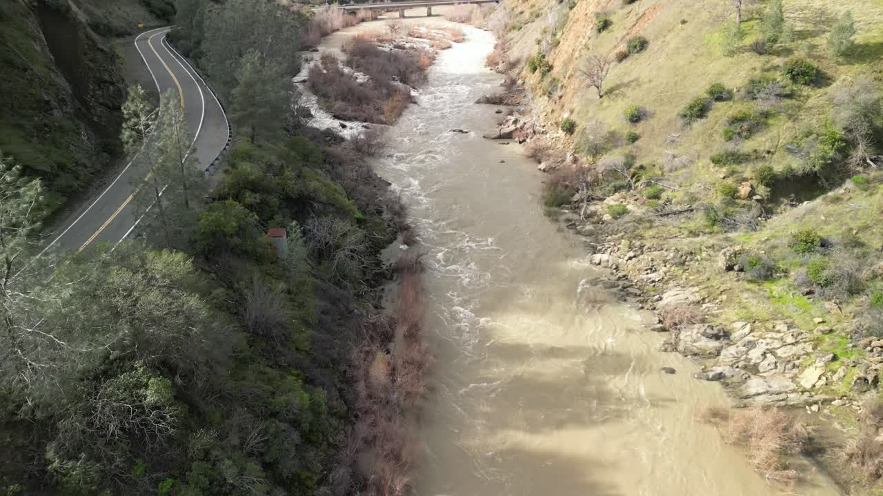 A drone soars over Cache Creek in Rumsey, highlighting the contrast between the water and the surrounding terrain.