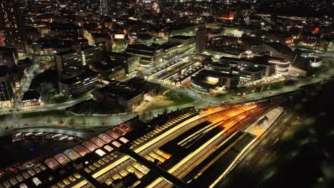 sinking aerial of sheffield train station and city lights at night