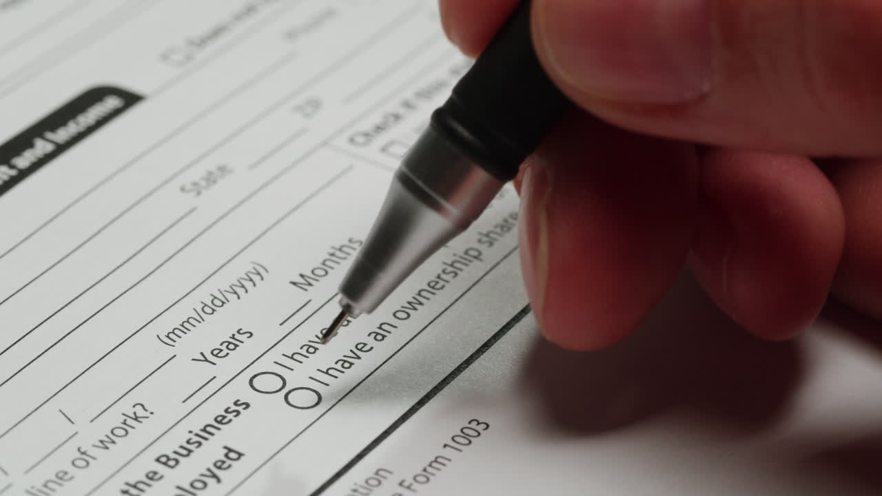 Close-up of Hand Filling Out a Business or Financial Form