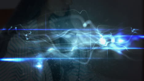 animación de rastros de luz sobre una mujer caucásica usando un teléfono inteligente
