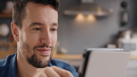 hombre feliz usando una tableta digital navegando por internet permaneciendo conectado en casa