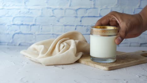 man hand holding glass of milk at early morning ,