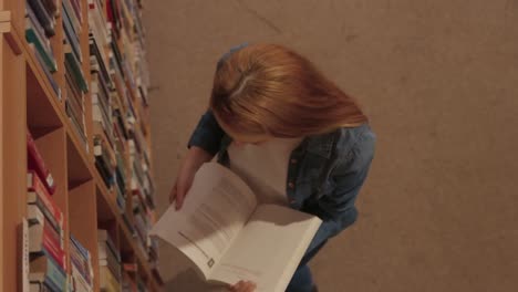 student reading a book in the library