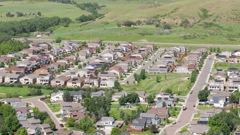 Pan-right-aerial-view-of-suburban-neighborhood-in-the-summer-with-renewable-and-green-rooftop-solar-panels-to-help-the-climate