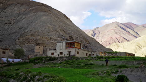 tiro inclinado hacia abajo a un pueblo remoto en la caminata del valle de markha, como un hombre subiendo una colina