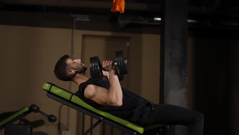 atleta masculino musculoso haciendo manos de cría con pesas a un lado