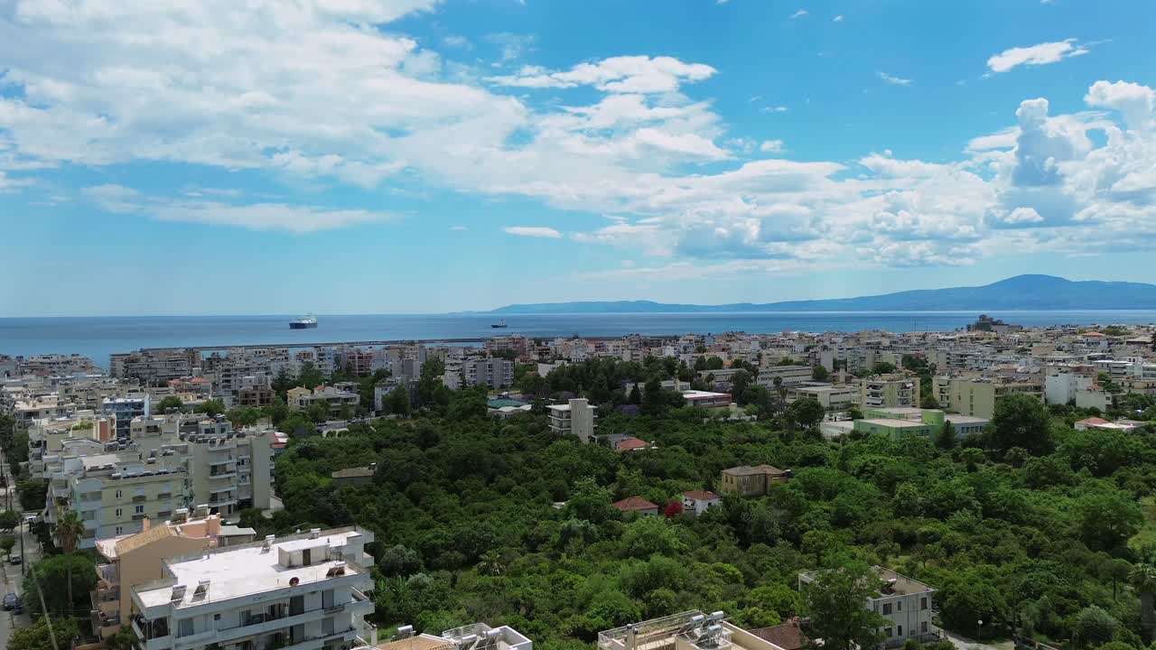 Aerial fast right pan , wide view of Messinian bay and Taygetos mountain, view from center of Kalamata city on a cloudy spring day 4K