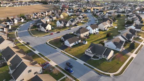 Aerial-tilt-up-reveal-of-sprawling-American-neighborhood-during-golden-hour-sunset