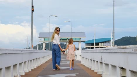 mother and daughter enjoying a walk on a pier