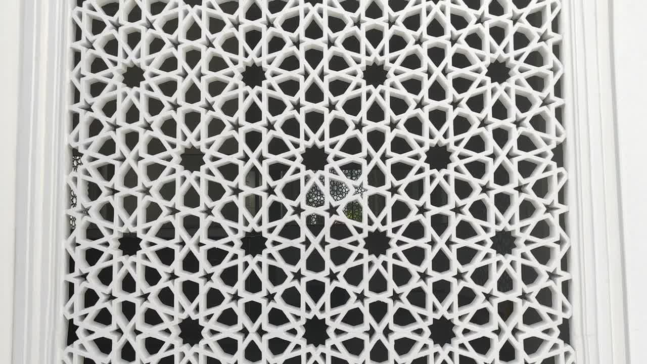 A building with Islamic geometric patterns as architectural elements for ventilation, lighting, and privacy, blocking outside views while enhancing aesthetics.