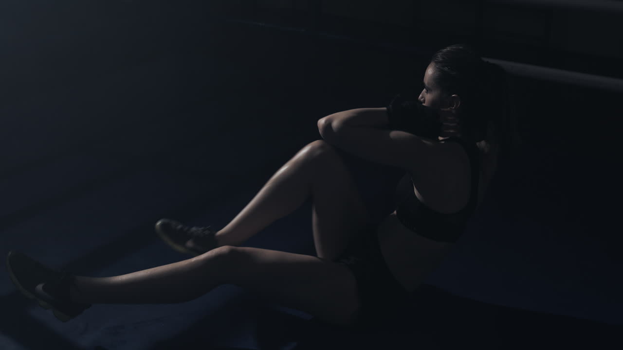 Woman Doing Core Workout in Dimly Lit Gym