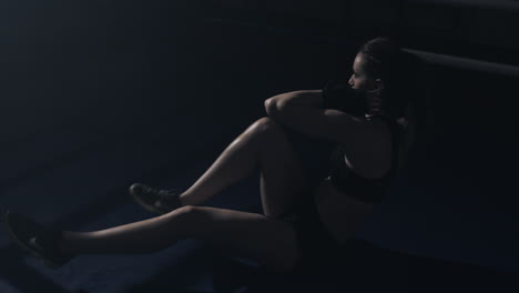 woman doing core workout in dimly lit gym