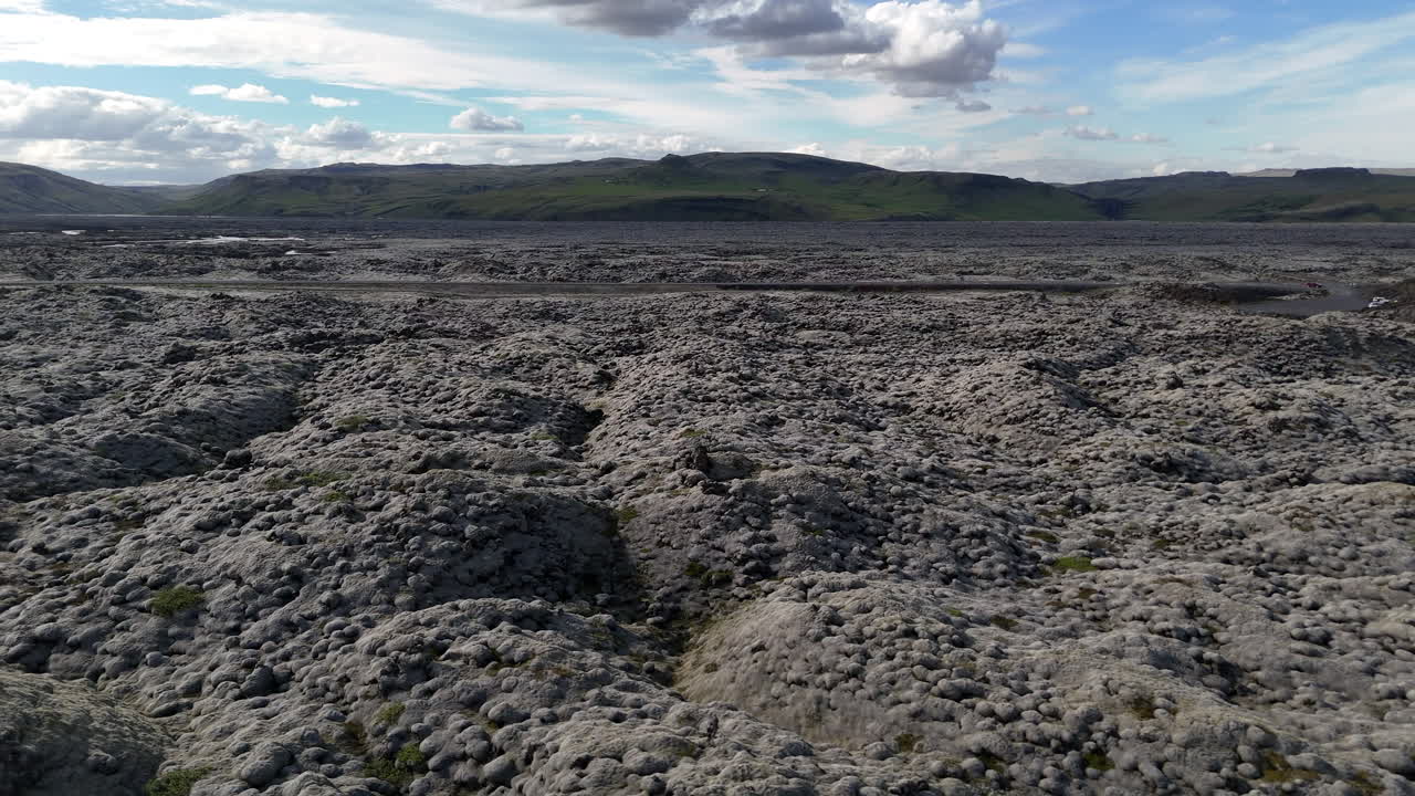 Luminosa veduta aerea del vasto campo di lava ricoperto di muschio islandese sotto nuvole sparse, che mette in mostra trame vulcaniche uniche e la bellezza aspra degli altopiani