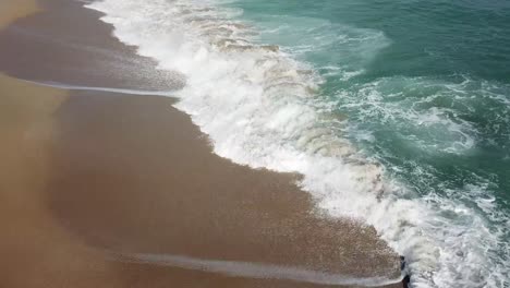 Slow-tilt-up-above-water-reveling-the-landscape-of-the-beautifulcoast-of-the-Maresme,-Catalunya,-Spain