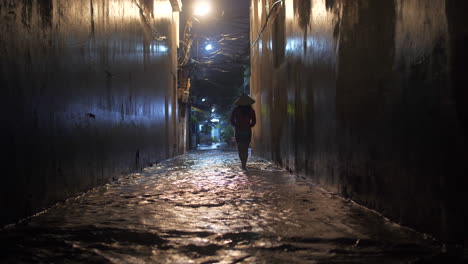 a woman walks down a flooded alley on a rainy night