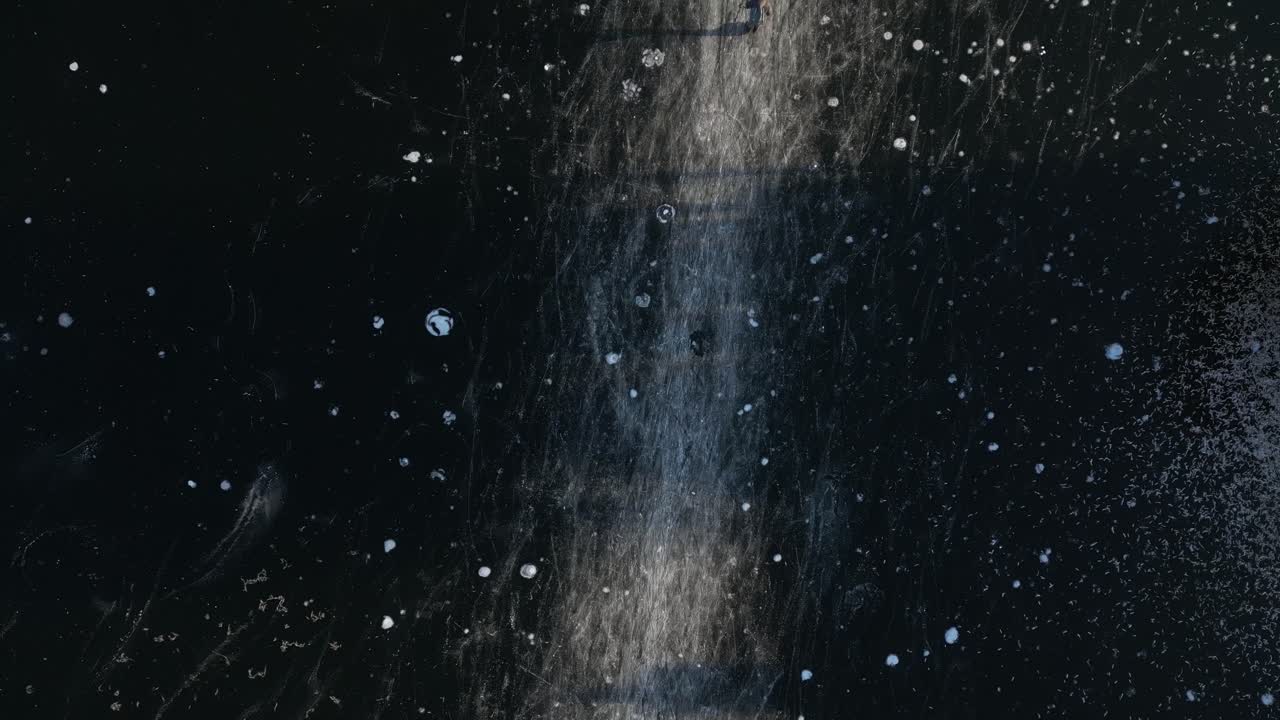 persona patinando sobre hielo en un río congelado con huellas en la superficie durante el invierno en los países bajos