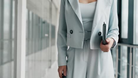 primer plano de un traje azul femenino en una mujer flaca con un cuaderno y un teléfono inteligente