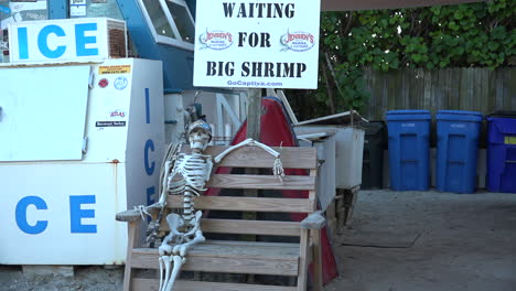 a humorous display shows a skeleton waiting for big shrimp