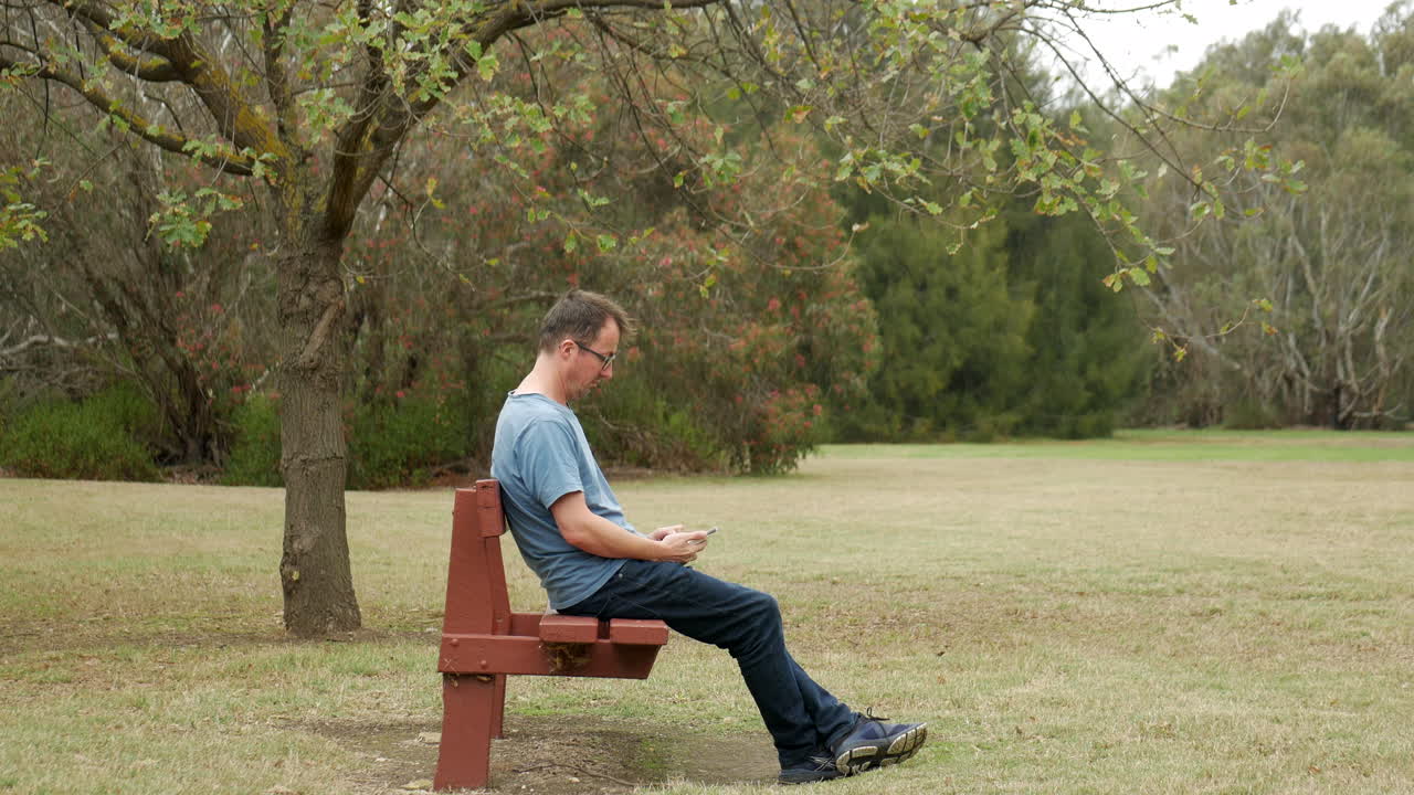 남자는 문자를 보고 웃는다