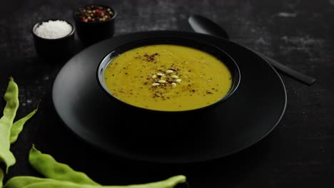 creamy soup with green pea in a ceramic white plate