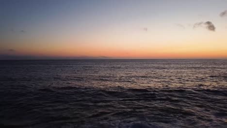 disparo de drones volando lejos del agua hacia la playa durante la puesta de sol