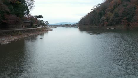 Tranquilo-Río-Katsura-Que-Sale-Hacia-Kyoto,-Tiro-Lento-Inclinado-Hacia-Arriba