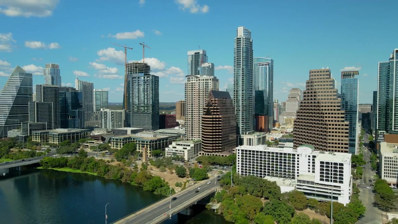 Filmagem aérea de drone do Centro de Austin, Texas, capturando a Congress Avenue estendendo-se em direção ao Rio Colorado. Plano de estabelecimento da cidade de Austin, filmado em um dia ensolarado com céu limpo