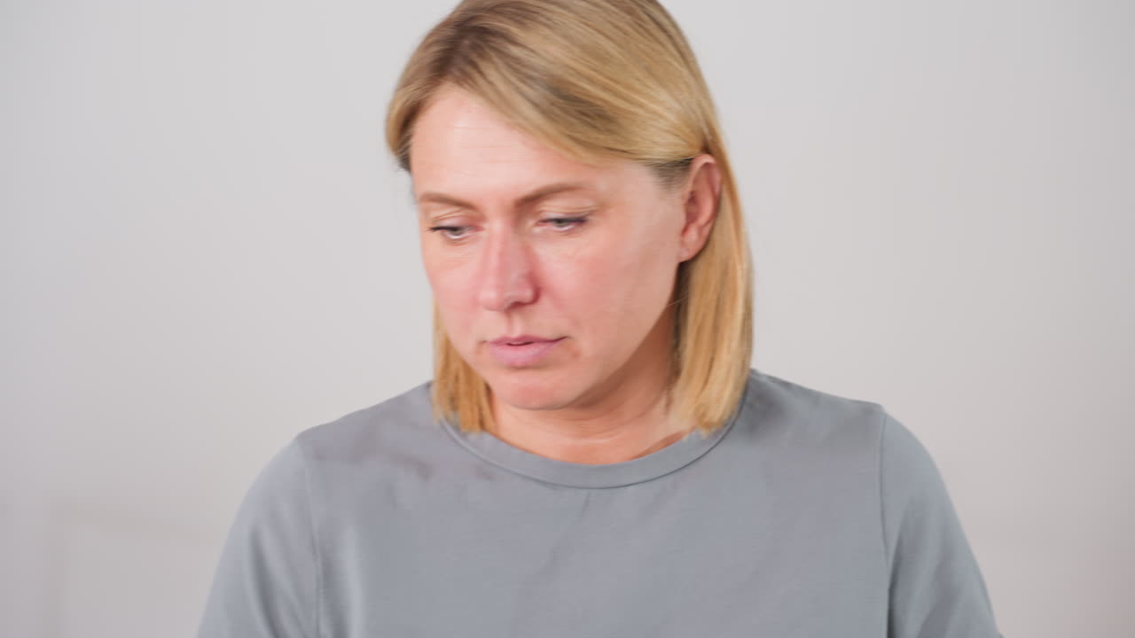 Craft women walking to table shaking head in neutral response during conversation, displaying thoughtful facial expression while engaging in creative discussion in bright modern workspace