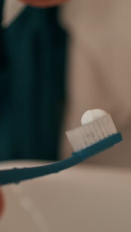 applying toothpaste to a toothbrush