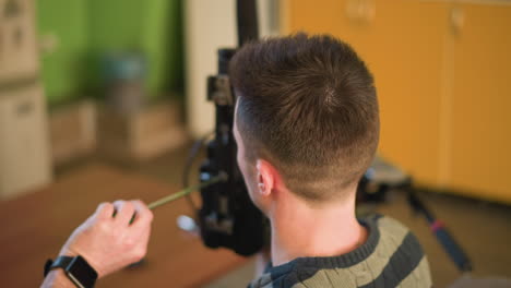 tv technician adjusting camera lens, setting up equipment, working with microphone, lights, preparing for video shoot in home studio or media production setup