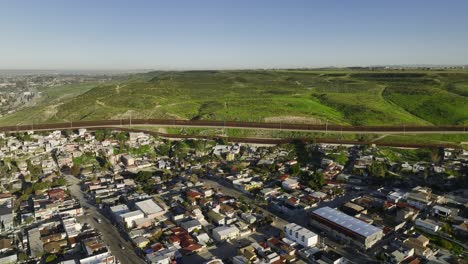 aerial view over mexican poverty, towards the border wall and west united states