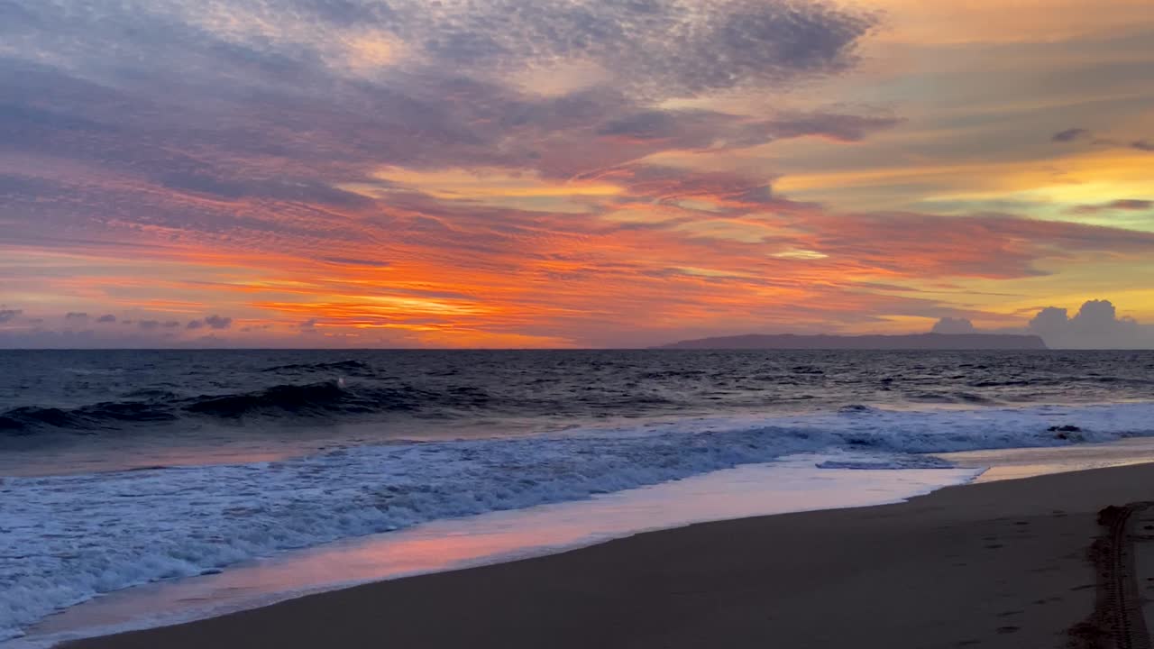 Stunning orange sunset sky over Niihau island seen from Kauai's Kekaha beach park
