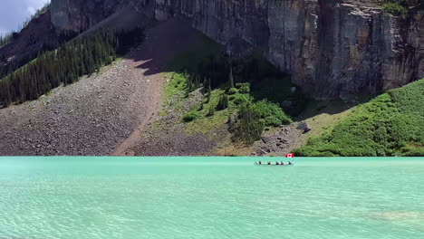 Voyageur-canoe-with-paddlers-and-Canada-flag-floats-on-Lake-Louise